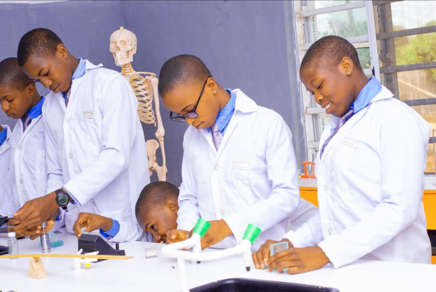 Theotokos students in lab coats doing a physics practical